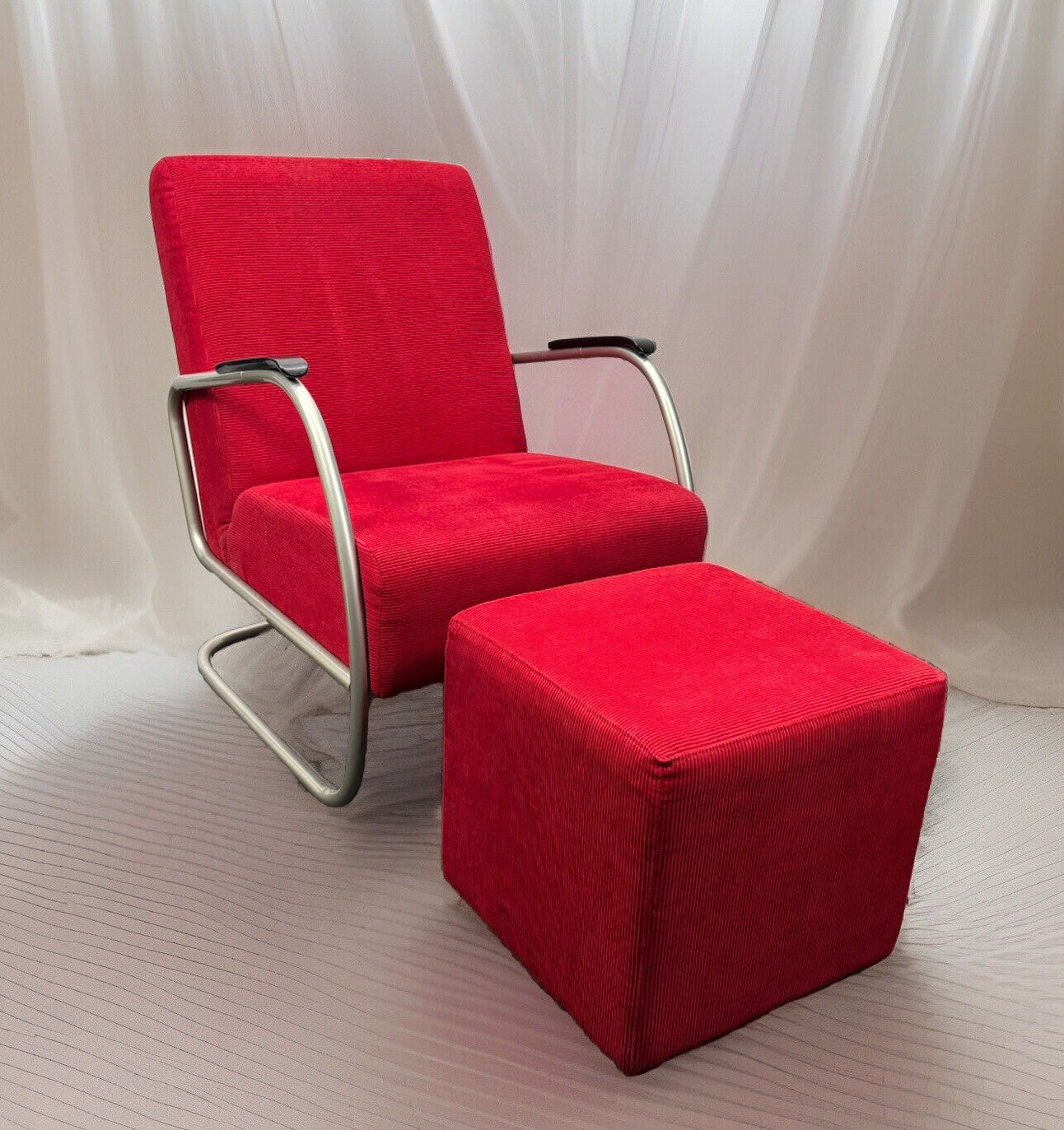 Bauhaus Freischwinger Sessel mit Hocker in Rot, modern für stilvolle Innenräume. Edelstahlrahmen und komfortables Design.
